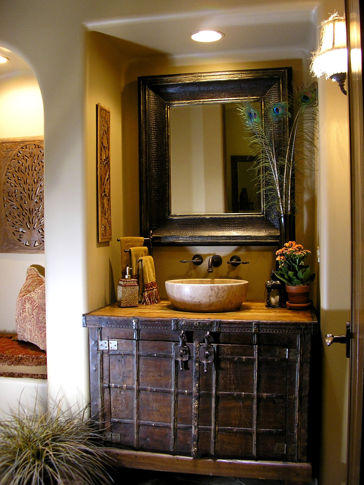 Inspiration for a traditional powder room in Phoenix with a vessel sink, wood benchtops, brown benchtops, furniture-like cabinets, dark wood cabinets and beige walls.