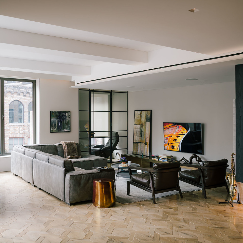 This is an example of a large contemporary formal open concept living room in New York with grey walls, light hardwood floors, no fireplace, a wall-mounted tv and beige floor.