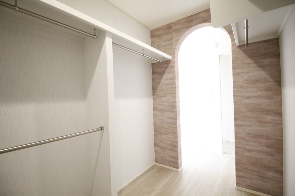 Esempio di una cabina armadio unisex minimalista con pavimento in compensato, pavimento beige e soffitto in carta da parati