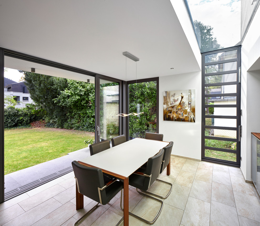 Mid-sized contemporary separate dining room in Frankfurt with white walls, slate floors, no fireplace and beige floor.