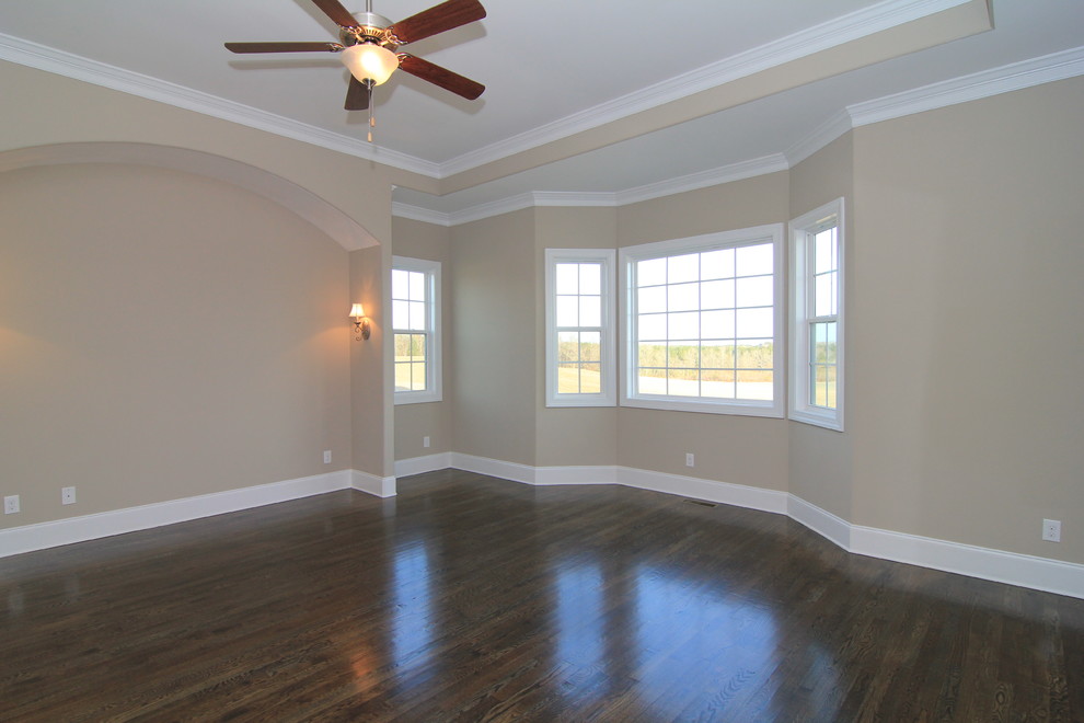 Inspiration for a large country master bedroom in Raleigh with beige walls and medium hardwood floors.