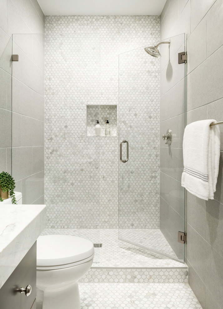 Inredning av ett klassiskt mellanstort vit vitt badrum, med släta luckor, skåp i mörkt trä, en dusch i en alkov, en toalettstol med hel cisternkåpa, grå kakel, marmorkakel, grå väggar, klinkergolv i porslin, ett undermonterad handfat, marmorbänkskiva, grått golv och dusch med gångjärnsdörr