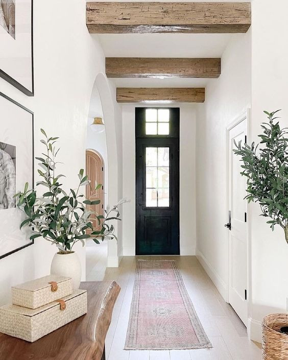 Ispirazione per un corridoio stile marino di medie dimensioni con pareti bianche, parquet chiaro, una porta singola, una porta nera, pavimento beige e travi a vista