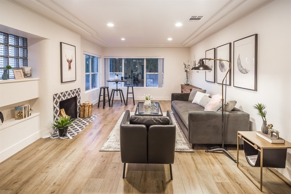 This is an example of a mid-sized transitional formal enclosed living room in San Diego with white walls, light hardwood floors, no fireplace and no tv.