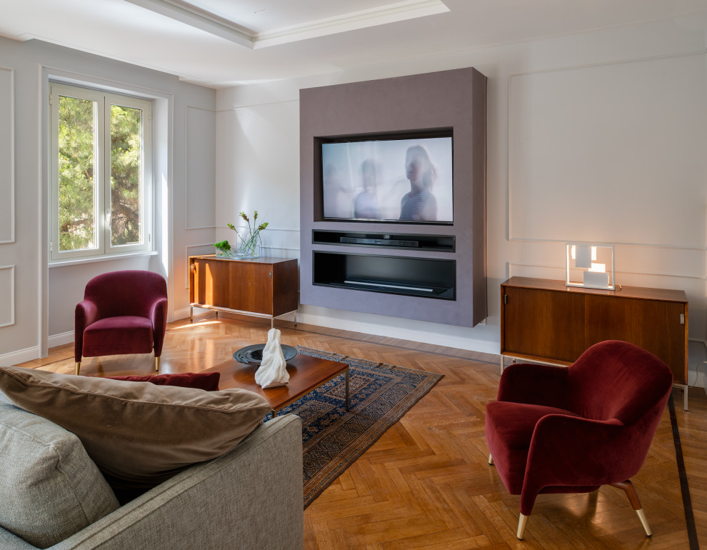 This is an example of an expansive contemporary open concept living room in Rome with a music area, grey walls, light hardwood floors, a hanging fireplace, a metal fireplace surround, a built-in media wall, brown floor and recessed.