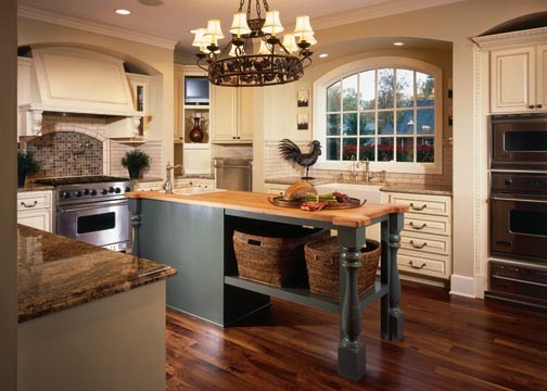 Mid-sized transitional u-shaped dark wood floor and brown floor enclosed kitchen photo with a farmhouse sink, raised-panel cabinets, white cabinets, wood countertops, multicolored backsplash, mosaic tile backsplash, stainless steel appliances and an island
