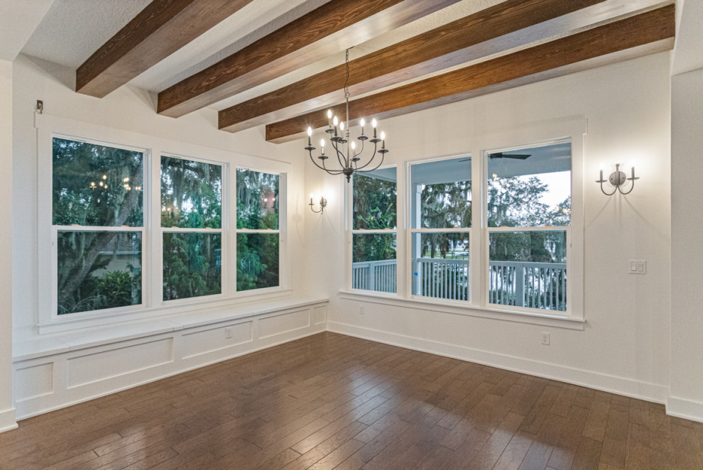 Photo of a mid-sized open plan dining in Jacksonville with white walls, medium hardwood floors, brown floor, exposed beam and decorative wall panelling.