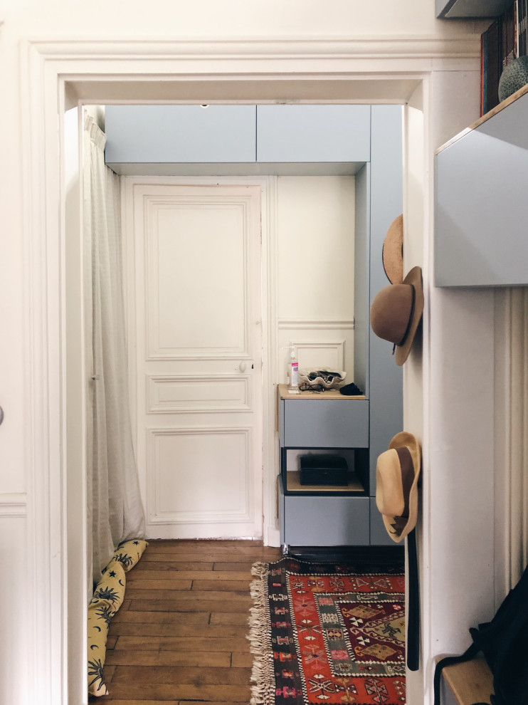 Foto de armario unisex minimalista pequeño con armarios con rebordes decorativos, puertas de armario de madera clara, suelo de madera en tonos medios y suelo marrón