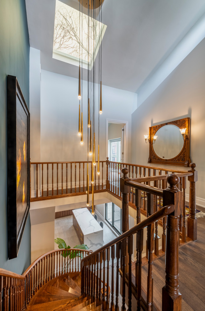 This is an example of a mid-sized contemporary wood curved staircase in Toronto with wood risers and wood railing.