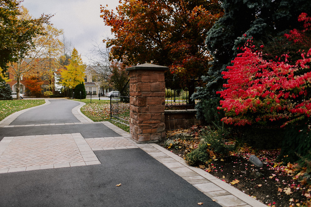 Large traditional front yard driveway in Toronto with brick pavers for fall.