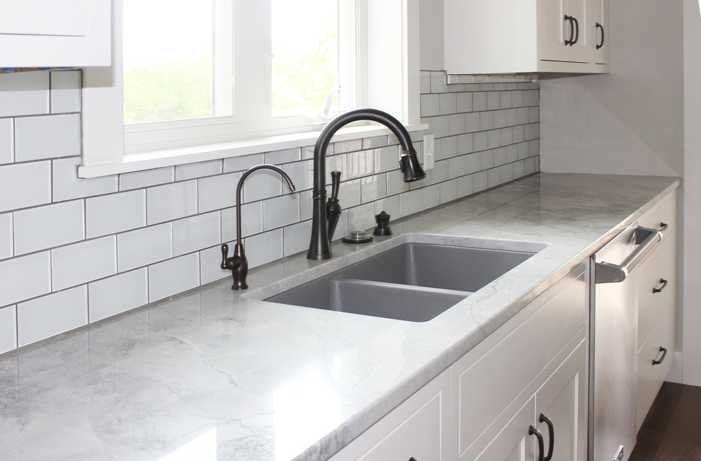 Inspiration for a large transitional l-shaped dark wood floor enclosed kitchen remodel in Cedar Rapids with a double-bowl sink, shaker cabinets, white cabinets, quartzite countertops, white backsplash, subway tile backsplash, stainless steel appliances and an island