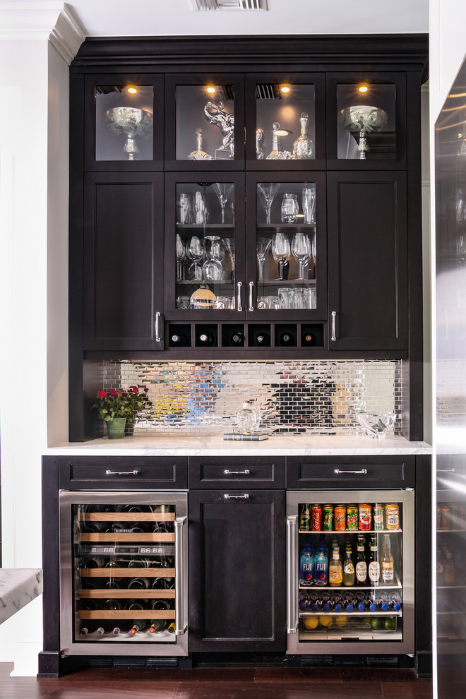 Small transitional single-wall wet bar in Tampa with no sink, recessed-panel cabinets, black cabinets, quartzite benchtops, grey splashback, metal splashback, dark hardwood floors, brown floor and white benchtop.