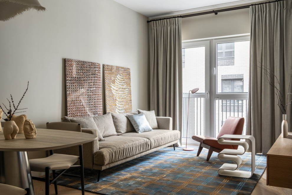 На фото: открытая гостиная комната в современном стиле с серыми стенами, паркетным полом среднего тона и коричневым полом с