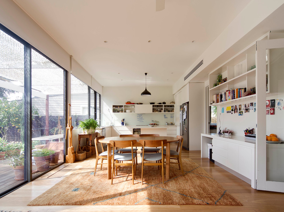 Inspiration for a mid-sized contemporary u-shaped eat-in kitchen in Melbourne with open cabinets, white cabinets, stainless steel appliances, an undermount sink, quartz benchtops, white splashback, glass sheet splashback, light hardwood floors and with island.