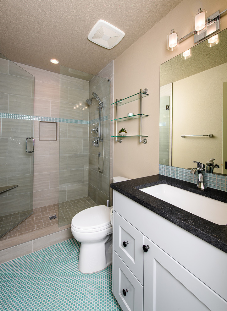 Example of a mid-sized transitional 3/4 beige tile and ceramic tile mosaic tile floor and blue floor alcove shower design with shaker cabinets, white cabinets, a two-piece toilet, beige walls, an undermount sink and a hinged shower door
