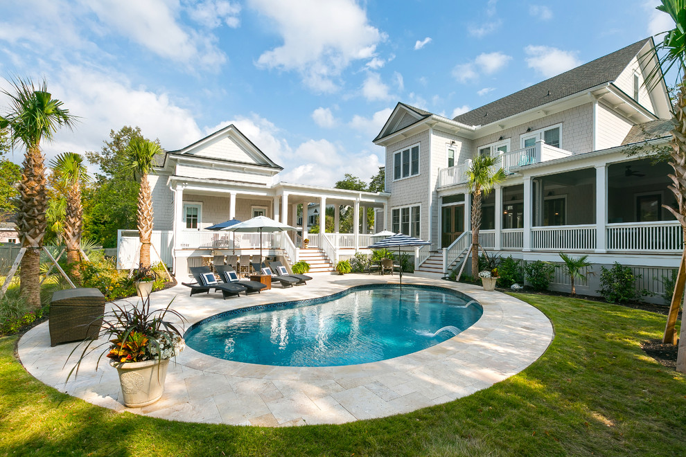 Design ideas for a beach style backyard kidney-shaped pool in Charleston with natural stone pavers.