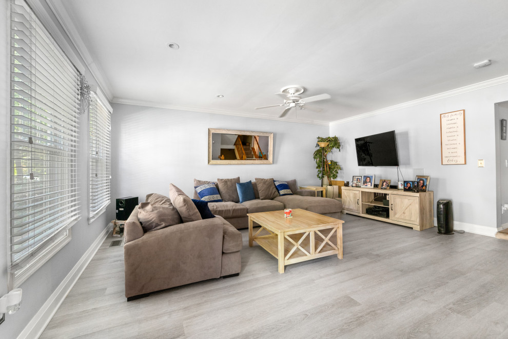 Foto di un soggiorno moderno di medie dimensioni e aperto con sala formale, pareti grigie, pavimento in vinile, TV a parete e pavimento grigio