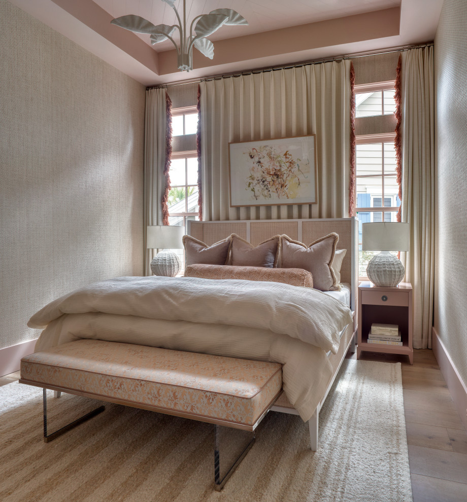 Bedroom - coastal guest medium tone wood floor, tray ceiling and wallpaper bedroom idea in Miami with pink walls