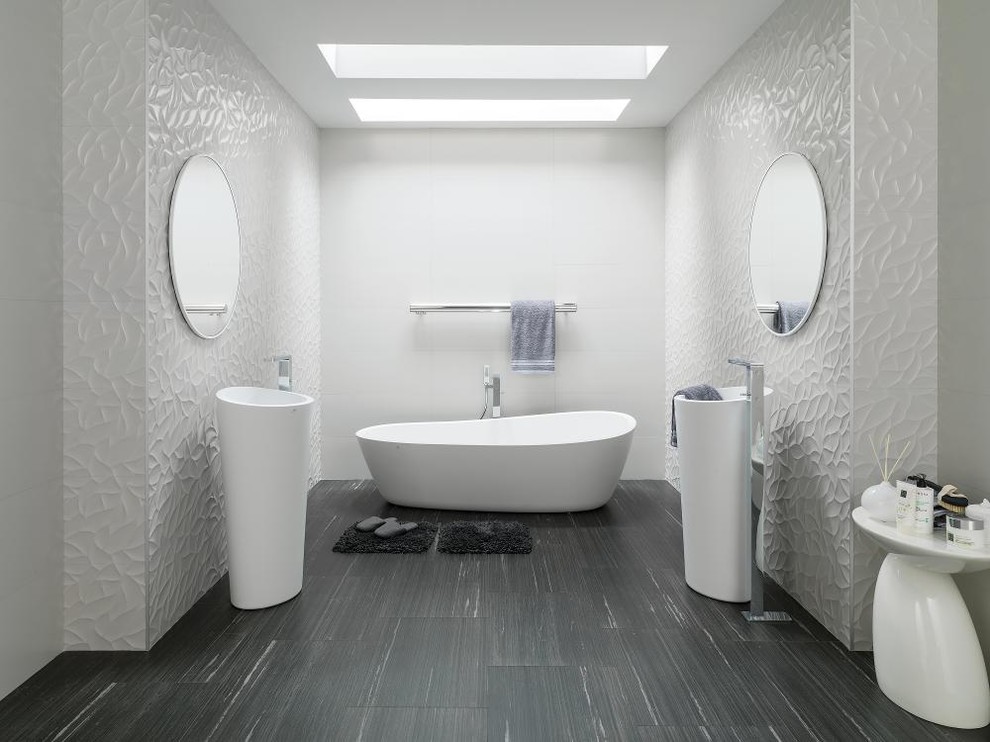 Photo of a large modern master bathroom in Vancouver with a freestanding tub, a one-piece toilet, white tile, porcelain tile, white walls, laminate floors, a pedestal sink and grey floor.