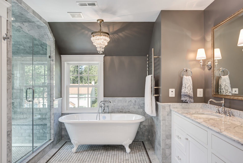 Mid-sized traditional master bathroom in DC Metro with shaker cabinets, white cabinets, a claw-foot tub, gray tile, marble, brown walls, marble floors, an undermount sink, marble benchtops, grey floor, grey benchtops, a corner shower and a hinged shower door.