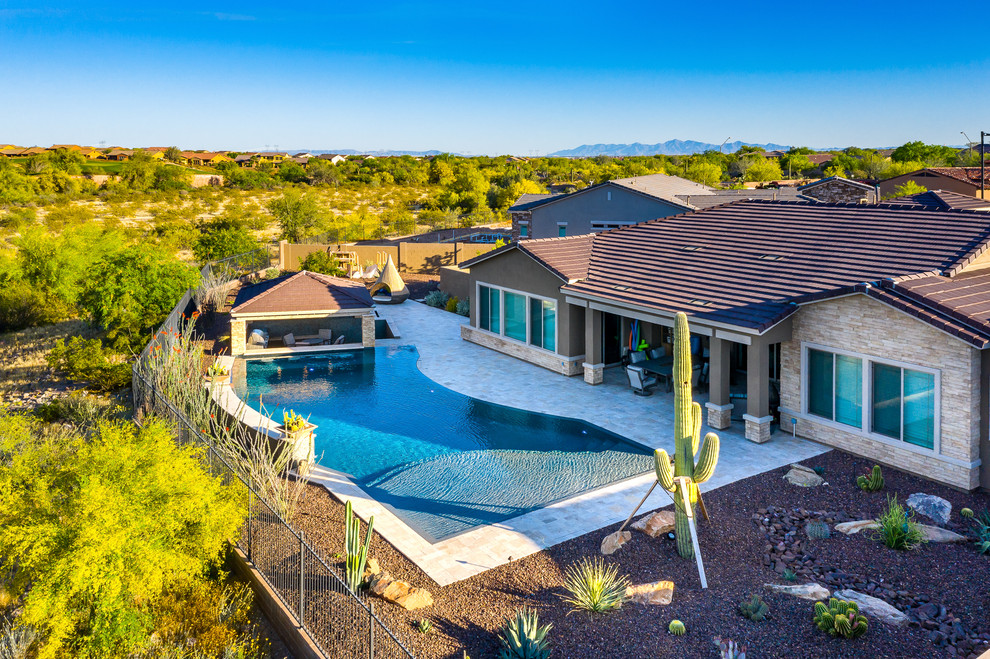 Inspiration for a large backyard stone and custom-shaped hot tub remodel in Phoenix