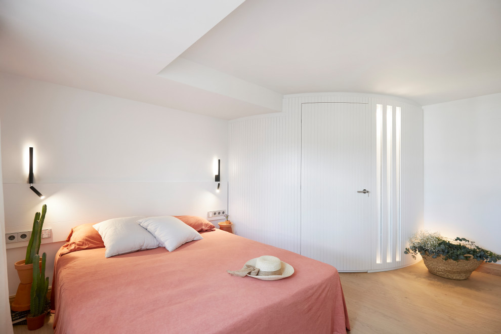 Ejemplo de habitación de invitados beige y blanca mediterránea de tamaño medio con paredes blancas, suelo de madera clara, suelo marrón y madera