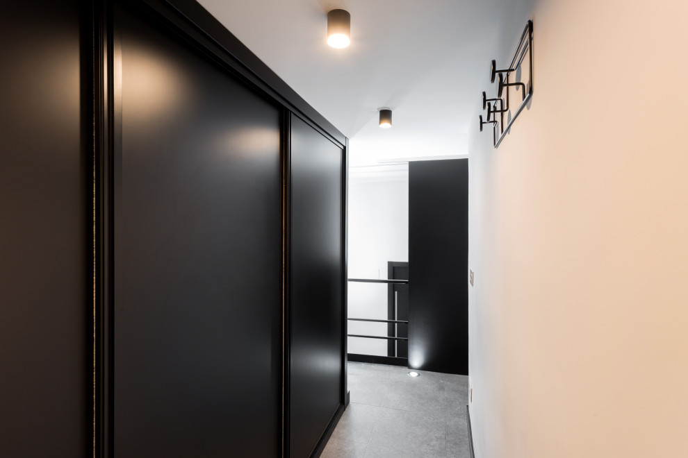 Стильный дизайн: маленькая гардеробная комната унисекс в стиле лофт с черными фасадами, полом из керамогранита и серым полом для на участке и в саду - последний тренд