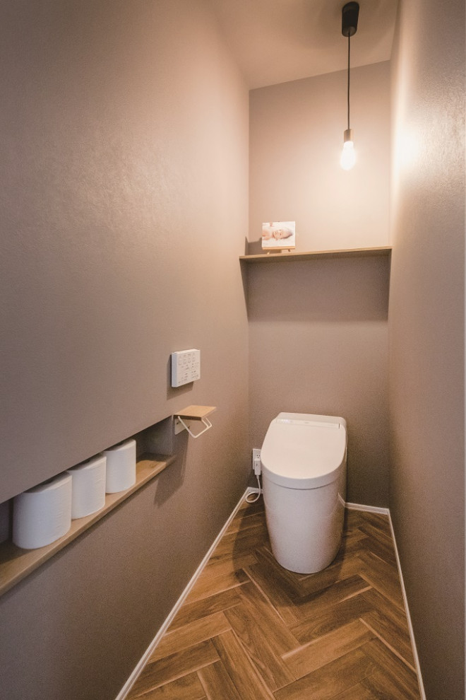 Exemple d'un WC et toilettes avec un mur gris, un sol marron, un plafond en papier peint et du papier peint.