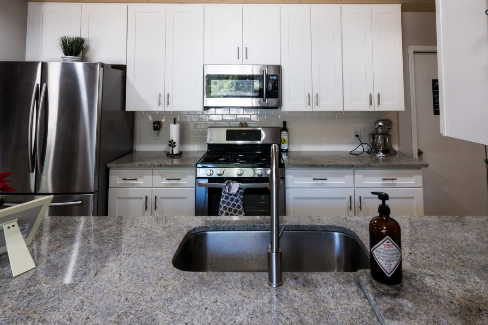 Inspiration for a small transitional cement tile floor and brown floor eat-in kitchen remodel with an undermount sink, shaker cabinets, white cabinets, granite countertops, white backsplash, cement tile backsplash, stainless steel appliances, a peninsula and white countertops