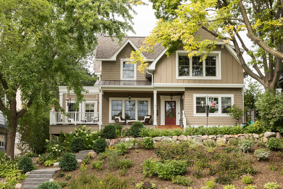 Traditional two-storey beige house exterior in Minneapolis with mixed siding, a gable roof and a shingle roof.