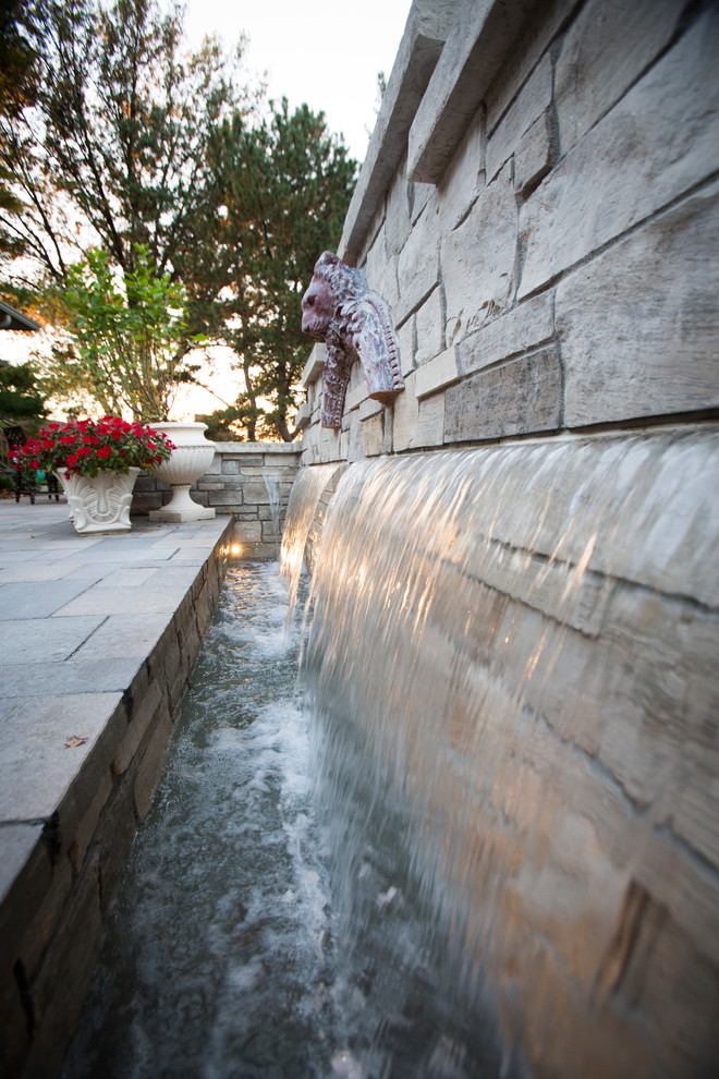 Inspiration for a transitional backyard stone water fountain landscape in Omaha.