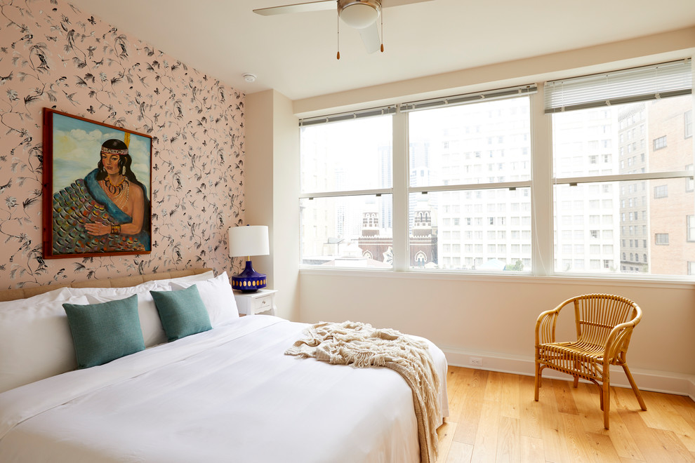 Inspiration for an eclectic bedroom in New Orleans with pink walls, medium hardwood floors and brown floor.
