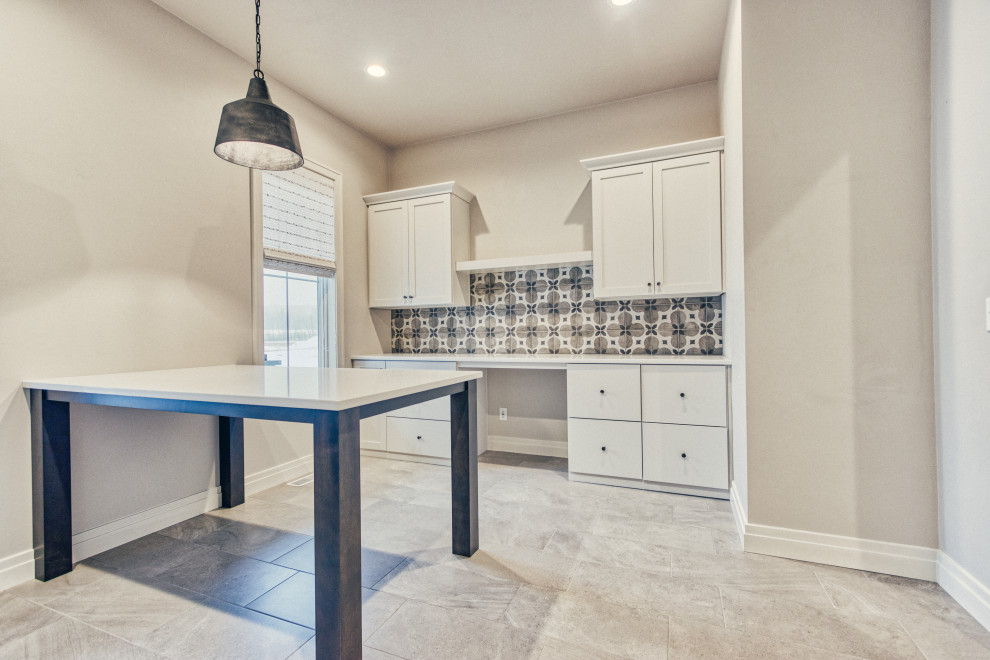 Example of a large transitional u-shaped ceramic tile and gray floor utility room design with an undermount sink, shaker cabinets, white cabinets, quartz countertops, gray walls, a side-by-side washer/dryer and white countertops