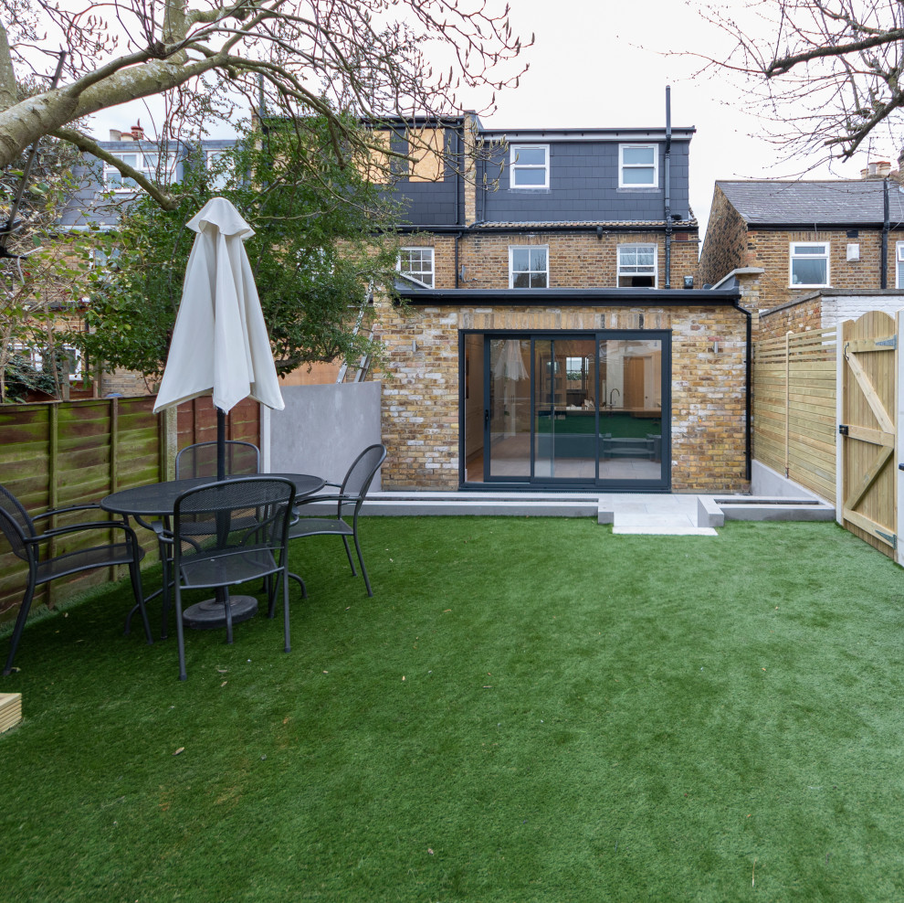 Small contemporary back garden in London with a wood fence.