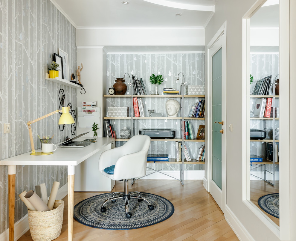 Scandinavian study room in Other with grey walls, light hardwood floors, a freestanding desk and beige floor.