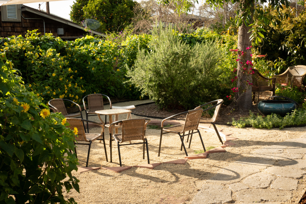 Esempio di un giardino xeriscape boho chic esposto in pieno sole di medie dimensioni e davanti casa in primavera con cancello e ghiaia