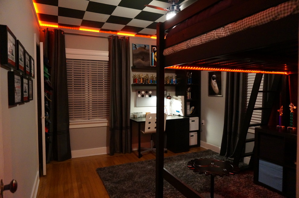 This is an example of a contemporary teen room for boys in San Francisco with grey walls and light hardwood floors.