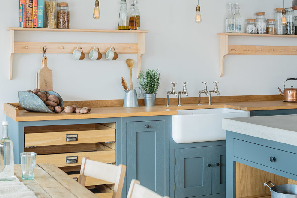 Mid-sized industrial l-shaped eat-in kitchen in Other with a farmhouse sink, shaker cabinets, grey cabinets, concrete benchtops, light hardwood floors and with island.