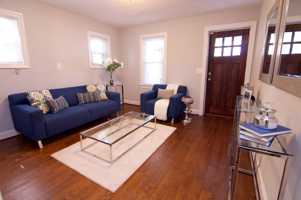 Photo of a small modern enclosed living room in DC Metro with grey walls, medium hardwood floors and no fireplace.