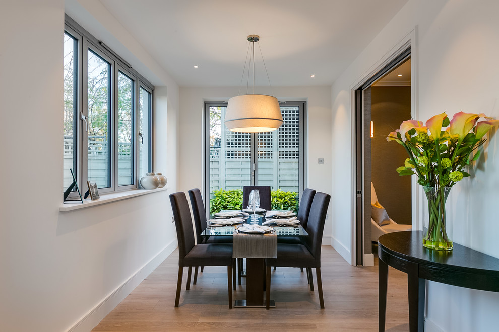 Inspiration for a contemporary open plan dining in London with medium hardwood floors.