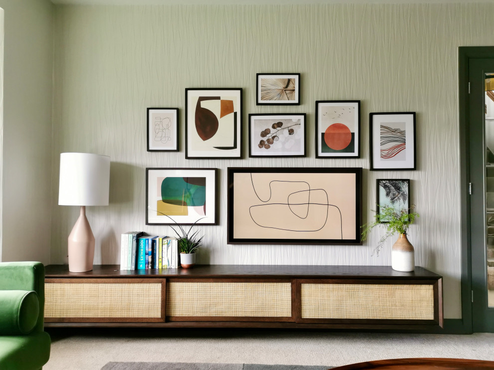 На фото: изолированная гостиная комната среднего размера в скандинавском стиле с серыми стенами, ковровым покрытием, телевизором на стене, бежевым полом и обоями на стенах без камина с