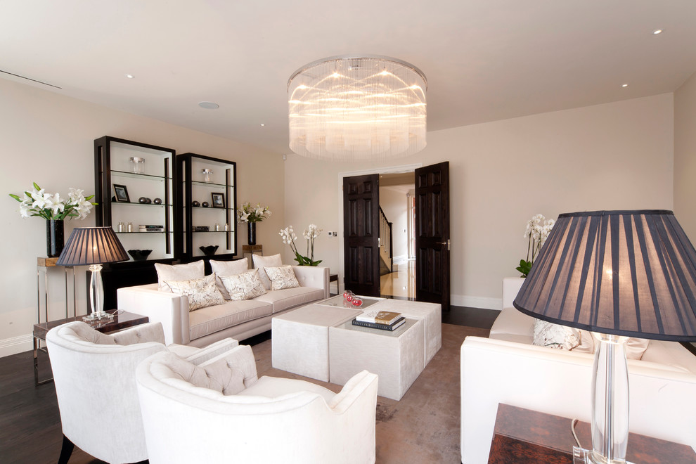 This is an example of a transitional living room in London with white walls, dark hardwood floors and no fireplace.