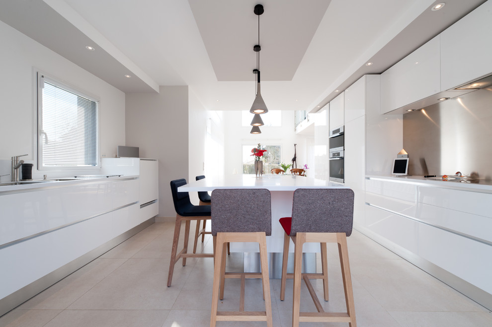 Large contemporary single-wall eat-in kitchen in Paris with an integrated sink, beaded inset cabinets, white cabinets, quartzite benchtops, grey splashback, metal splashback, panelled appliances and with island.