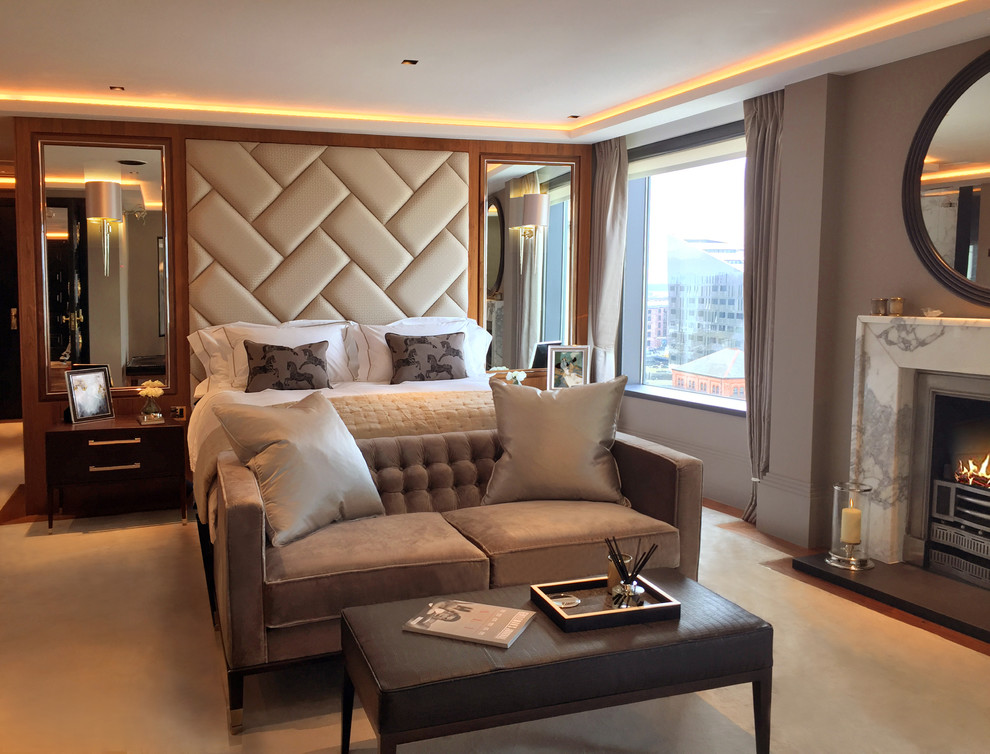 Design ideas for a large modern master bedroom in London with multi-coloured walls, carpet, a standard fireplace, a stone fireplace surround and beige floor.