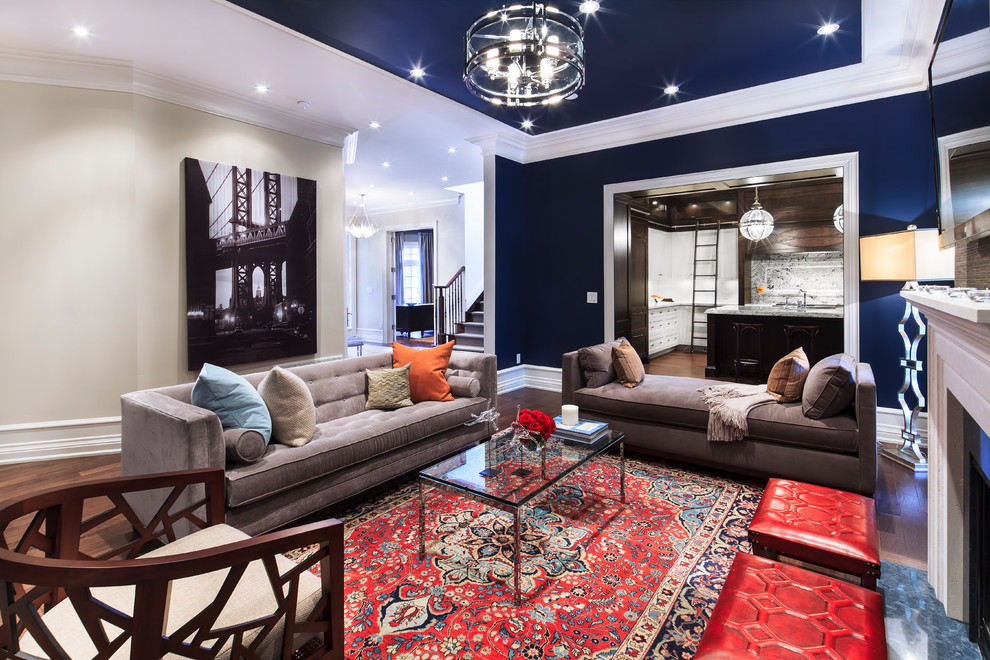 This is an example of a large contemporary open concept living room in New York with blue walls, a standard fireplace, a wall-mounted tv, medium hardwood floors and brown floor.
