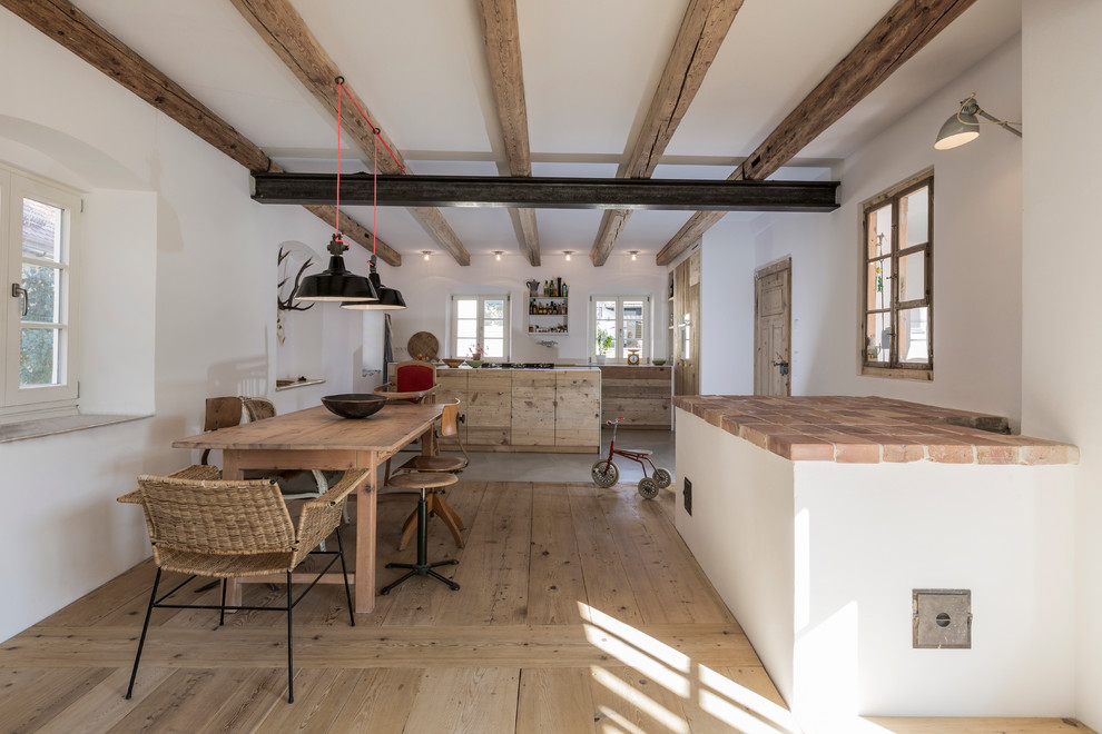 Photo of a large industrial galley open plan kitchen in Munich with an undermount sink, flat-panel cabinets, light wood cabinets, solid surface benchtops, concrete floors and with island.
