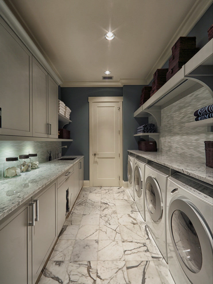 Photo of a transitional laundry room in Miami with grey cabinets and grey floor.