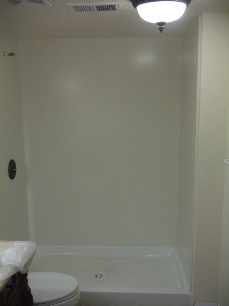Trendy 3/4 doorless shower photo with solid surface countertops