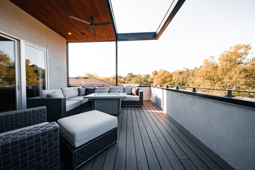 Inspiration for a large modern rooftop and first floor deck in Kansas City with a roof extension and metal railing.