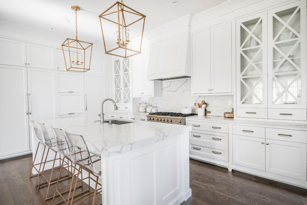 Inspiration for a transitional l-shaped kitchen in Chicago with shaker cabinets, white cabinets, white splashback, panelled appliances, medium hardwood floors, with island and brown floor.